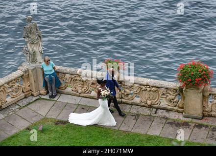 Brautpaar Braut und Bräutigam treffen einen Touristen in Villa Balbianello Garten, Lenno, Comer See, Italien Stockfoto