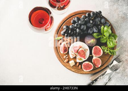 Camembert Käse mit Feigen, Trauben und Wein im Glas auf einem hölzernen Servierbrett, Draufsicht, Kopierraum Stockfoto