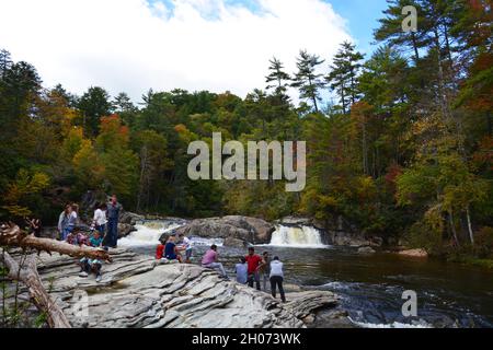 Besucher versammeln sich entlang der felsigen Ufer der oberen Linville Falls entlang des Blue Ridge Parkway in North Carolina. Stockfoto