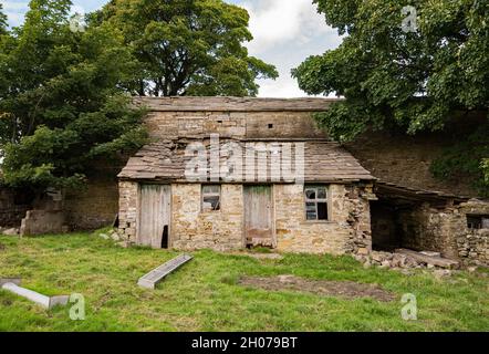 Eine in der Nähe verwelkende Scheune... in der Nähe von Wohnungen und in der Nähe der Creamery in Hawes, North Yorkshire Stockfoto