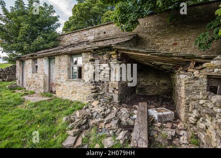 Eine in der Nähe verwelkende Scheune... in der Nähe von Wohnungen und in der Nähe der Creamery in Hawes, North Yorkshire Stockfoto