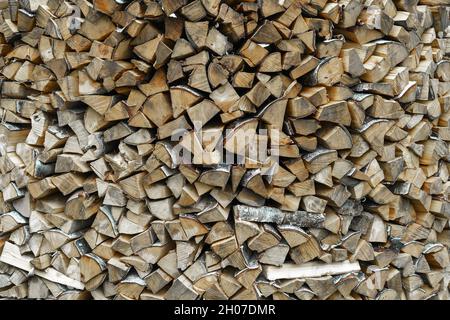 Getrocknetes Buchenholz bereit zum Erhitzen. Holzstapel im Stapel. Gehacktes Brennholz, auf einem Haufen getrocknet. Hintergrundstruktur aus Holz. Stockfoto