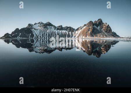 Luftdrohnenansicht eines herrlichen sonnigen Tages und einer wunderschönen Reflexion des Vestrahorn Bergs auf dem Stokksnes Kap in Island. Lage: Stokksnes Kap Stockfoto