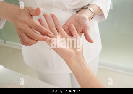 Junge Frau, die im Spa-Salon eine Akupunkturbehandlung zur Hand hat. Konzept der alternativen Medizin Stockfoto