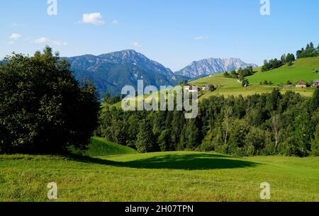 Landschaftlich reizvolle Aussicht auf ein Landhaus und die grünen Wiesen in den österreichischen Alpen der Region Schladming-Dachstein (Österreich) Stockfoto