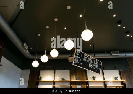 San Diego, California, USA - 6. August 2021: Interieur mit entspannter Atmosphäre im Café mit Fokus auf Decke, Lampen und hängenden Menüs Stockfoto