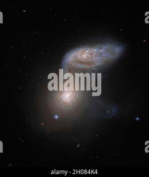 Dieses NASA-Bild der Woche zeigt zwei interagierende Galaxien, die so miteinander verflochten sind, dass sie einen kollektiven Namen haben – Arp 91. Dieser zarte galaktische Tanz findet über 100 Millionen Lichtjahre von der Erde entfernt statt und wurde vom NASA/ESA Hubble Space Telescope aufgenommen. Die beiden Galaxien, aus denen Arp 91 besteht, haben ihren eigenen Namen: Die untere Galaxie, die in diesem Bild wie ein heller Fleck aussieht, wird als NGC 5953 bezeichnet; und die ovoide Galaxie rechts oben ist NGC 5954. In Wirklichkeit sind beide Galaxien Spiralgalaxien, aber ihre Formen erscheinen sehr unterschiedlich, weil sie unterschiedlich ausgerichtet sind Stockfoto