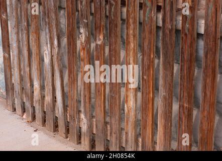 Doppelwand aus Holzzäunen und alten Zementblöcken, die in einer Kleinstadt entdeckt wurden und die Menschen daran hindern, einen Raum zu sehen und zu betreten. Foto im Winkel. Stockfoto