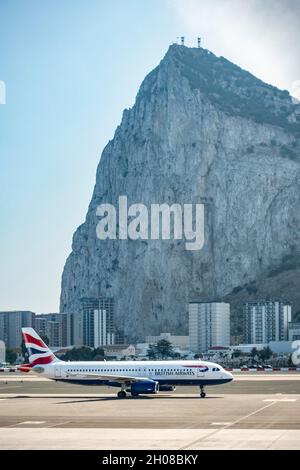 British Airways Airbus A320-232 Ankunft und Start-und Landebahn am Flughafen Gibraltar. Der Felsen von Gibraltar ist im Hintergrund. Stockfoto