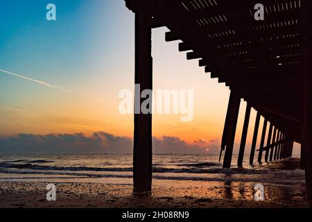 Aufgehende Sonne unter dem Claremont Pier Lowestoft Stockfoto