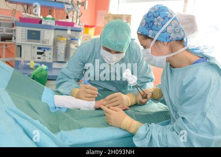 Chirurg, der die Operation an der Hand des Patienten durchführt Stockfoto