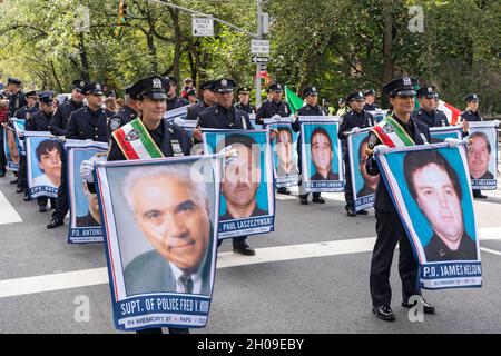 New York, Usa. Oktober 2021. Polizeibeamte der Hafenbehörde halten bei der jährlichen Columbus Day Parade auf der Fifth Avenue in Manhattan, New York City, Plakate mit Bildern der gefallenen Beamten. Die jährliche Veranstaltung feiert den Tag, an dem Christoph Kolumbus 1492 in Amerika landete. Kredit: SOPA Images Limited/Alamy Live Nachrichten Stockfoto