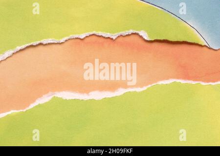Zerrissenes Papier in Zitronengrün und Blau auf orangefarbenem Hintergrund. Kopie für Werbefläche. Stockfoto