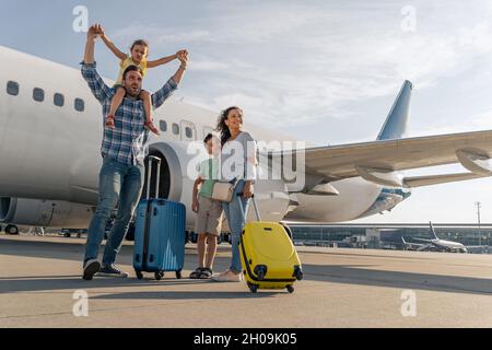 Glückliche Eltern und ihre Kinder warten darauf, gemeinsam zu reisen Stockfoto