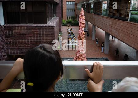 Hongkong, China. Oktober 2021. Ein kleines Mädchen sah, wie sie mit ihren Eltern die Säule der Schande vor ihrer Entfernung von der Universität von Hongkong (HKU) sah.am letzten Tag vor der Entfernung der Säule der Schande durch die Universität von Hongkong (HKU) forderte die HKU den Organisator des HK Tiananmen Massakers am 4. Juni, Um die Säule der Schande vor dem Termin von morgen - 13. Oktober, 5 Uhr zu entfernen. Der vom dänischen Künstler Jens Galschiøt geschaffene Pfeiler der Schande wurde seit 1997 24 Jahre an der Hong Kong University errichtet und ausgestellt. Kredit: SOPA Images Limited/Alamy Live Nachrichten Stockfoto