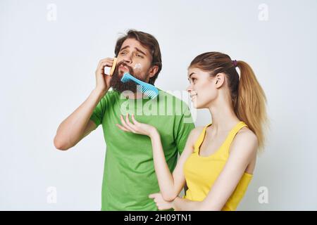 Bärtiger Mann neben einer Frau, die sich im Badezimmer eine Gesichtsbehandlung anschert Stockfoto