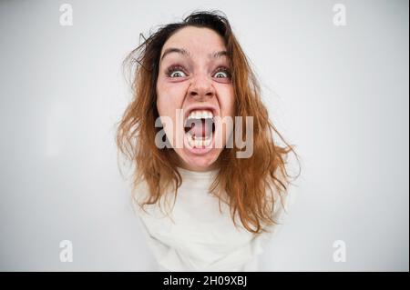 Nahaufnahme Porträt einer verrückten Frau in Zwangsjacke auf weißem Hintergrund. Stockfoto