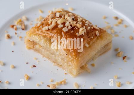 Türkische Baklava mit Haselnüssen auf einem weißen Porzellanteller Stockfoto