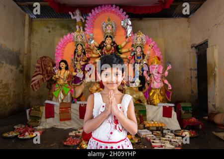 Narayanganj, Dhaka, Bangladesch. Oktober 2021. Ein Kind zeigt Namaskar (Willkommensgeste) vor einem Durga-Idol während des hinduistischen Religionsfestivals Durga Puja in Narayanganj, Bangladesch. (Bild: © Joy Saha/ZUMA Press Wire) Stockfoto