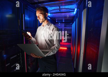 IT-Spezialist, der Sicherheitsanwendung und Laptop für die Serververwaltung verwendet Stockfoto