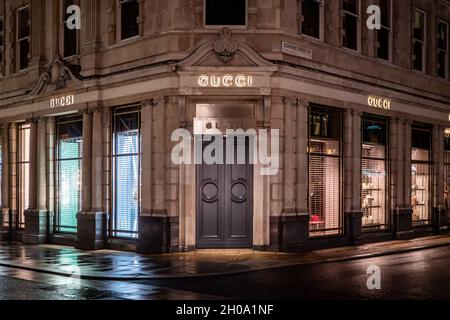 Der Gucci Store, Bond Street, London. Das Gucci Fashion Store im wohlhabenden Londoner Einkaufsviertel. Geschlossene, beleuchtete Nachtansicht. Stockfoto