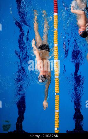 Männlicher professioneller Schwimmer im Schwimmbad Stockfoto