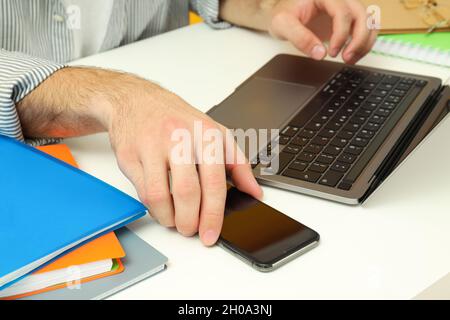 Arbeitsplatzkonzept mit männlichen Händen und Zubehör auf weißem Tisch. Stockfoto