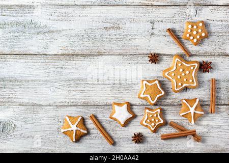 Ecke der Weihnachts Lebkuchen in Form eines Sterns mit Mustern aus Glasur und Gewürzen auf einem weißen Holzhintergrund. Draufsicht mit Kopierbereich Stockfoto