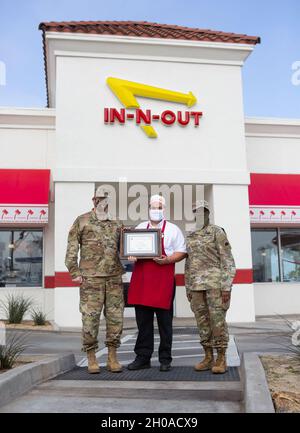 Kaplan der US-Armee (Col.) Russell Dewell, links, der als Staatskaplan der California National Guard fungiert, und California State Guard Chaplain (Maj.) Brenda ThreatT, rechts, übergibt Benjamin Corona, einem in-N-Out Store Manager, am 8. Januar 2021 in Long Beach, Kalifornien, ein patriotisches Arbeitgeberzertifikat. Anfang November besuchte ein in-N-Out Cookout Truck den nahe gelegenen Joint Forces Training Base in Los Alamitos und bot Dienstmitgliedern der California State Guard auf Basis für ihre jährliche Schulung kostenlose Mahlzeiten an. Stockfoto