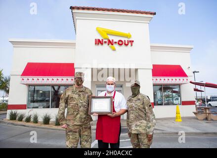 Kaplan der US-Armee (Col.) Russell Dewell, links, der als Staatskaplan der California National Guard fungiert, und California State Guard Chaplain (Maj.) Brenda ThreatT, rechts, übergibt Benjamin Corona, einem in-N-Out Store Manager, am 8. Januar 2021 in Long Beach, Kalifornien, ein patriotisches Arbeitgeberzertifikat. Anfang November besuchte ein in-N-Out Cookout Truck den nahe gelegenen Joint Forces Training Base in Los Alamitos und bot Dienstmitgliedern der California State Guard auf Basis für ihre jährliche Schulung kostenlose Mahlzeiten an. Stockfoto