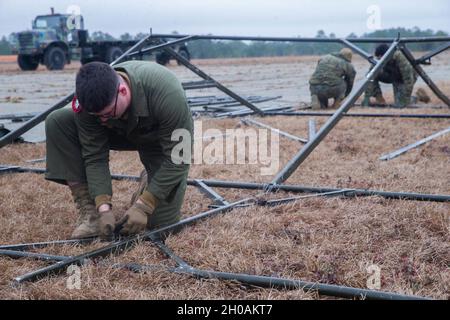 US Marine Corps Sgt. Ethan Chivari, ein Techniker der Bordelektronik, baut ein Zelt zur Vorbereitung auf die Übung Black Shadow in Fort Stewart, Georgia, 12. Januar 2021. Marines with Unmanned Aerial Vehicle Squadron 2 (VMU-2), die mit Soldaten der Combat Aviation Brigade, 3. Infanterie-Division in einer unbekannten Umgebung trainiert wurden, um die Fähigkeiten in kritischen Missionen wie Luftaufklärung, Geleitzug und Unterstützung der Nahluftunterstützung zu verbessern. VMU-2 ist eine untergeordnete Einheit des 2nd Marine Aircraft Wing, des Luftkampfelements der II Marine Expeditionary Force. Stockfoto