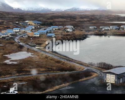 Eine Hubschrauber-Crew der Küstenwache Kodiak MH-60 Jayhawk nähert sich dem Dorf Akhiok, um Personal der Kodiak Area Native Association (KANA) bei der Lieferung von COVID-19-Impfstoffen in Akhiok, Alaska, zu unterstützen, 12. Januar 2021. Die Küstenwache und das Personal VON KANA arbeiten zusammen, um COVID-19-Impfstoffe an die abgelegenen Gemeinden auf Kodiak Island zu liefern. US-Küstenwache Stockfoto