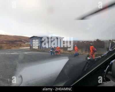Eine Küstenwache-Luftstation Kodiak MH-60 Jayhawk-Hubschraubercrew unterstützt Mitarbeiter der Kodiak Area Native Association (KANA) beim Transport von Hilfsgütern und COVID-19-Impfstoffen in Akhiok und Karluk, Alaska, 12. Januar 2021. Die Küstenwache und Mitarbeiter VON KANA arbeiten zusammen, um COVID-19-Impfstoffe an die abgelegenen Gemeinden auf Kodiak Island zu liefern. Stockfoto