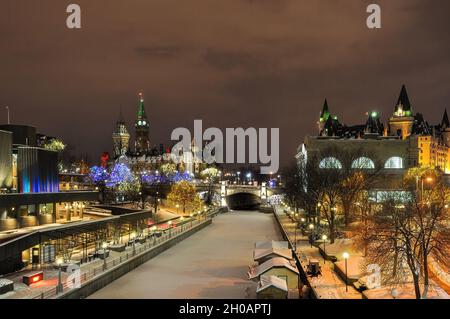 Neblige Winternacht mit Weihnachtslichtern des National Arts Centre und des Parlamentsgebäudes, L, Rideau Canal Stockfoto