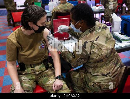 Befehl Sgt. Maj. Eva Commons, das Hauptquartier- und Hauptquartier-Bataillon, 82. Kommandofeldwebel Major der Luftlanddivision, erhält die COVID-19-Impfung bei Sports USA in Fort Bragg, N.C., 14. Januar 2021. Stockfoto