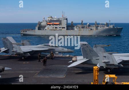 210114-N-DQ752-1016 NORDARABISCHES MEER (JAN 14, 2021) der USNS Matthew Perry (T-AKE-9) dampft während einer Replenishment-at-Sea Evolution neben USS Nimitz (CVN 68). Nimitz, das Flaggschiff der Nimitz Carrier Strike Group, wird im 5. Einsatzgebiet der US-Flotte eingesetzt, um die maritime Stabilität und Sicherheit in der Zentralregion zu gewährleisten, indem es das Mittelmeer und den Pazifik durch den westlichen Indischen Ozean und drei kritische Drosselpunkte mit dem freien Fluss des globalen Handels verbindet. Stockfoto