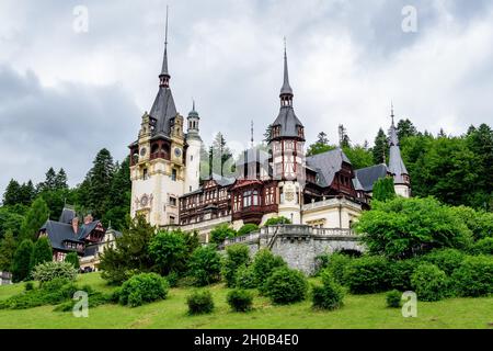 Schönes Neorenaissance-Gebäude der Burg Peles (Castelul Peles) in der Nähe des Bucegi-Gebirges (Muntii Bucegi) an einem bewölkten Sommertag in Sinaia, römisch Stockfoto