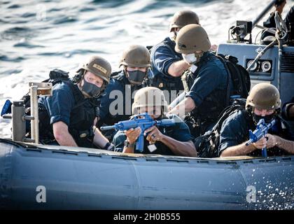 Segler führen ‘einem Schlauchboot „Hufeisenmanöver“ durch, bevor sie während einer Visit-, Board-, Such- und Beschlagnahmungs-Übung (VBSS) an Bord des Arleigh Burke-Klasse-Lenkflugkörper-Zerstörers USS John S. McCain (DDG 56) gehen. McCain wird dem Destroyer Squadron (DESRON) 15 zugewiesen, dem größten vorwärtseingesetzten DESRON der Marine und der wichtigsten Surface Force der US-Flotte der 7. Flotte. Stockfoto