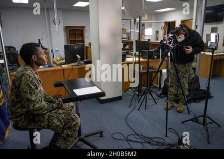 210115-N-GG858-1002 OKINAWA, Japan (Jan 15, 2021) Yeoman Seaman Richard Reddick (links), aus Jacksonville, Florida, dem Kommandanten von Fleet Activities Okinawa (CFAO) zugewiesen, wird vom Mass Communication Specialist 1st Class David Krigbaum aus Los Angeles, Kalifornien, für ein Video zur Einweihung des Martin Luther King Jr. Day im CFAO-Hauptquartier auf dem Luftwaffenstützpunkt Kadena in Okinawa, Japan, gefilmt. Januar 15, 2020. CFAO unterstützt das gesamte Spektrum der Navy-Operationen auf Okinawa und seine Hauptmandantenkommandos sind Commander Task Force 76, Naval Mobile Construction Bataillon 5 und Patrol und Reconnaissance Force 7. Flotte. Stockfoto