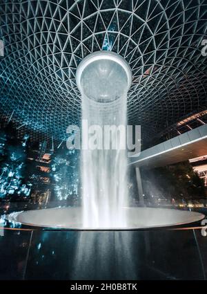 SINGAPUR, SINGAPUR - 23. Aug 2019: Eine vertikale Aufnahme des berühmten Wasserfalls des Jewel Changi Airport in Singapur Stockfoto