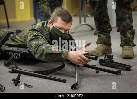 Ein deutscher Feldjaeger 3-Militärpolizist, der der NATO-verstärkten Vorwärtspräsenz Battlegroup Lithuania zugewiesen wurde, zeigt das 2. Bataillon der USA, 8. Kavallerie-Regimenttroopers, das MG 3-Maschinengewehr, das sie am 16. Januar 2021 auf dem Schlachtfeld von Pabrade, Litauen, auf dem Schlachtfeld führen. Die NATO-Partnerkräfte demonstrierten die Fähigkeiten, wie man zusammenbricht und wieder zusammenbaut, eine Funktionsprüfung durchführt und die Waffensysteme der anderen, die üblicherweise auf dem Schlachtfeld eingesetzt werden, feuern kann. Die Demonstration erhöhte die Interoperabilität des Schlachtfelds, falls ein Soldat auf das Schlachtfeld fallen sollte und ein ausländischer Mitkämpfer Stockfoto