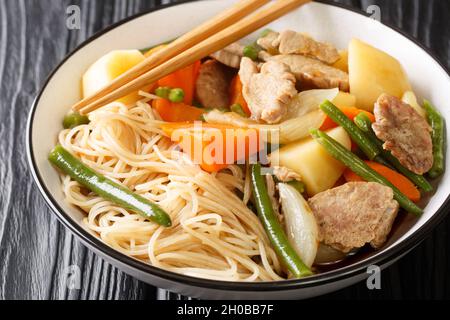 Nikujaga Fleisch und Kartoffeln im japanischen Stil in einer Schüssel auf dem Holztisch aus nächster Nähe eintoben. Horizontal Stockfoto