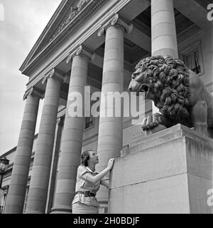 Eine Frau Vor der Löwenstatue bin Eingang von Schloss Rosenstein in Bad Cannstatt Bei Stuttgart, Deutschland, 1930er Jahre. Eine Frau vor einem Löwe Skulptur am Eingang der Burg Rosenstein in Bad Cannstatt bei Stuttgart der 1930er Jahre. Stockfoto