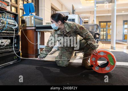 US Air Force Staff Sgt. Ashleigh Sisneros, mit dem 159. Kampfflügel der Louisiana Air National Guard, rollt ein Netzwerkkabel ab, während er Kommunikationsgeräte im US-Kapitolgebäude in Washington, D.C. aufbaute, um die Interoperabilität mit Bundes- und Bezirkspartnern als Teil der Unterstützung für die 59. Amtseinführung am 18. Januar 2021 sicherzustellen. Mindestens 25,000 Männer und Frauen der Nationalgarde wurden autorisiert, Sicherheits-, Kommunikations- und Logistikmissionen zur Unterstützung der Bundes- und Bezirksbehörden durchzuführen, die die 59. Amtseinführung des Präsidenten vorführten. Stockfoto