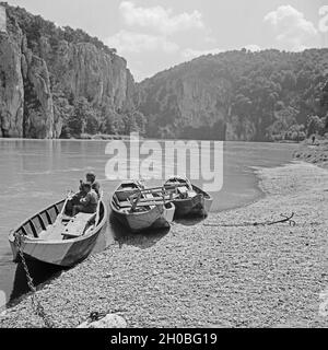 Ruderboote auf der Donau vor dem Kloster Weltenburg, Deutschland 1930er Jahre. Ruderboote am Ufer der Donau bei Weltenurg Abtei, Deutschland 1930. Stockfoto