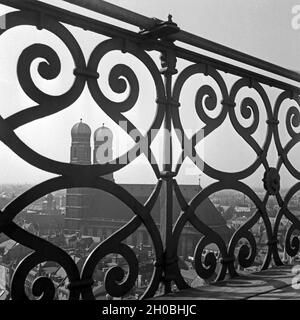 Blick auf die Frauenkirche in München vom Turm der Kirche St. Peter, Deutschland 1930er Jahre. Blick auf die Münchner Frauenkirche durch das Geländer der Glockenturm der Kirche St. Peter, Deutschland 1930. Stockfoto