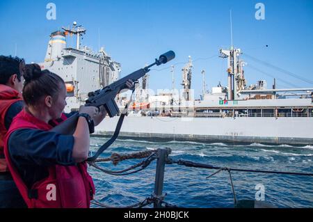 210119-N-PS962-1038 ARABIAN SEA (JAN 19, 2021) – Gunners Mate 3rd Class Sydney Hedge feuert eine Schusslinie an Bord des Lenkraketenzerstörers USS Winston S. Churchill (DDG 81) während eines Auffüllens auf See mit Flottennachfüllungsöler USNS Leroy Grumman (T-AO 195) im Arabischen Meer, Januar 19. Winston S. Churchill wird in das Einsatzgebiet der 5. Flotte der USA eingesetzt, um Marineinteraktionen zu unterstützen, um die maritime Stabilität und Sicherheit in der Zentralregion zu gewährleisten, indem es das Mittelmeer und den Pazifik durch den westlichen Indischen Ozean und drei kritische Drosselpunkte mit dem freien Fluss von Global Comerc verbindet Stockfoto