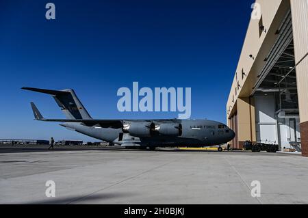 Die der 911. Instandhaltungsgruppe zugeordneten Flieger schleppen einen C-17 Globemaster III aus dem zwei-Bay-Hangar und zurück zur Fluglinie an der Pittsburgh International Airport Air Reserve Station, Pennsylvania, 19. Januar 2021. Luftfahrzeuge schleppen Flugzeuge in den Hangar, um Wartungsarbeiten durchzuführen, die durch raue Wetterelemente beeinträchtigt werden könnten, wenn sie im Freien durchgeführt werden. Stockfoto
