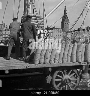 Hafenarbeiter im Hafen von Elbing, im Hintergrund die Nikolaikirche, Masuren, Ostpreußen, Deutschland 1930er Jahre. Arbeitnehmer bei Elbing Hafen, im Hintergrund St. Nicolas Kirche, Masuren, Ostpreußen, Deutschland 1930. Stockfoto