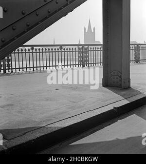 Das filigrane Brückengeländer der Hindenburgbrücke über den Rhein in Köln mit Blick auf die Kirche Groß St. Martin, Deutschland 1930er Jahre. Die filigrane Brüstung an der Hindenburgbrücke über den Rhein von Deutz nach Köln-Stadt mit Blick auf die St. Martins-Kirche, Deutschland 1930er Jahre. Stockfoto